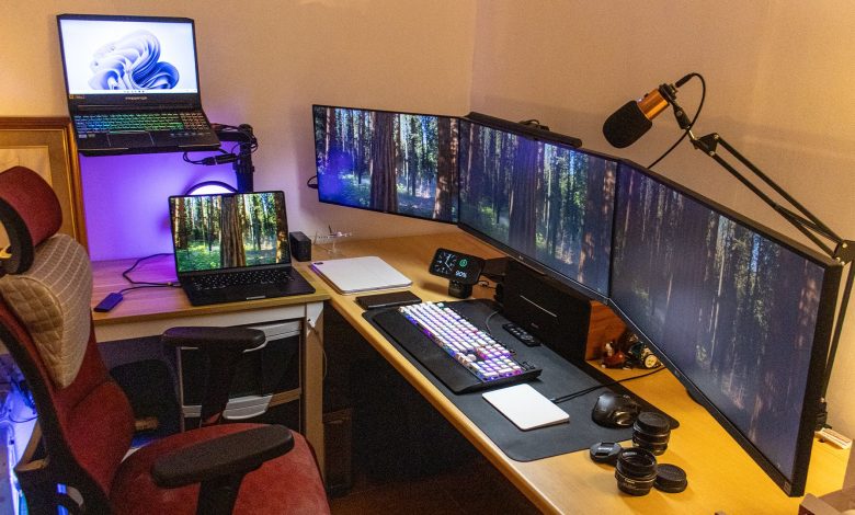 A triple-monitor work setup with a MacBook and Windows laptop.