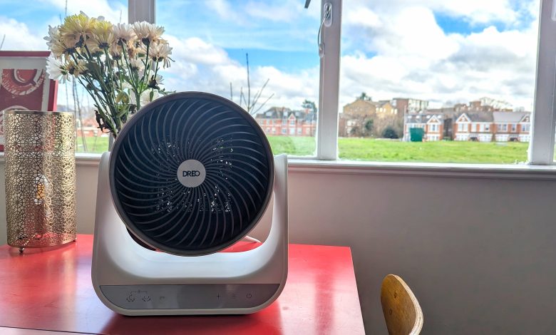 The Dreo Smart Whole Room Heater 714s on a red table, in front of a window