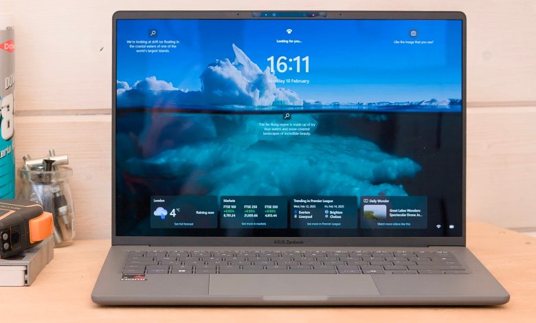 The Asus Zenbook A14 pictured from the front on a wood workbench