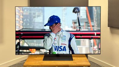 The 65-inch LG G5 OLED TV pictured on a wooden rack. On the screen is a still from Netflix F1 series Drive to Survive.