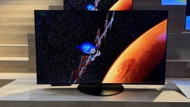 The Panasonic Z86C OLED TV pictured at a press event. On the screen is an image of a satellite orbiting an orange planet.