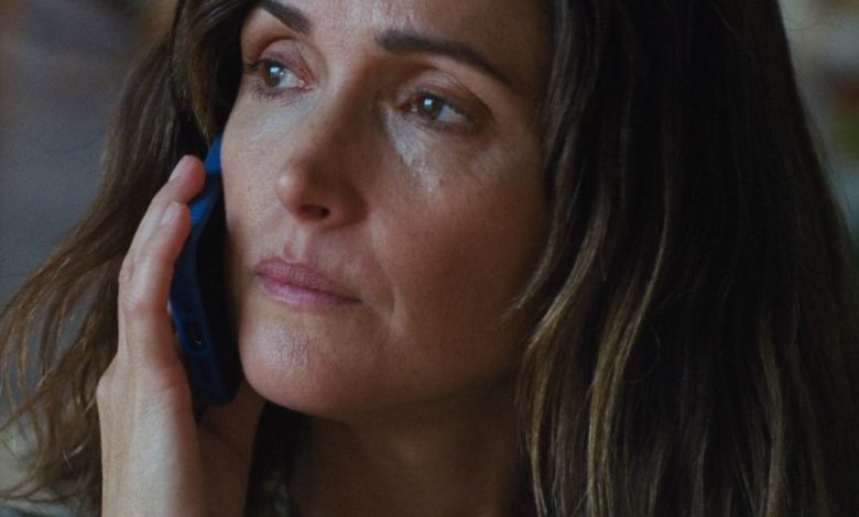 Rose Byrne's character Linda answers the phone and looks off in the distance.