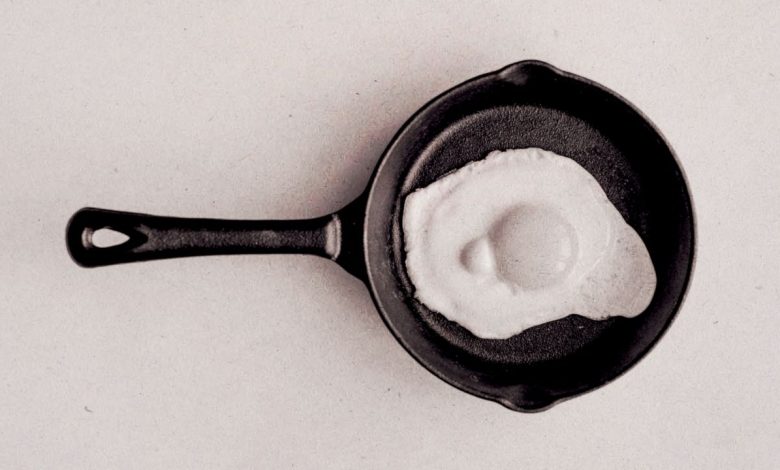 Photograph of an egg frying in a pan, edited to resemble the 1987 'this is your brain on drugs' PSA.