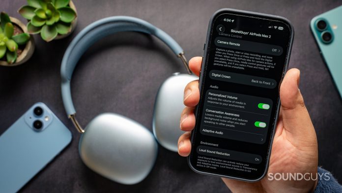 Apple AirPods Max 2 headphones on table with iPhone 17 Pro in front showing different software features.