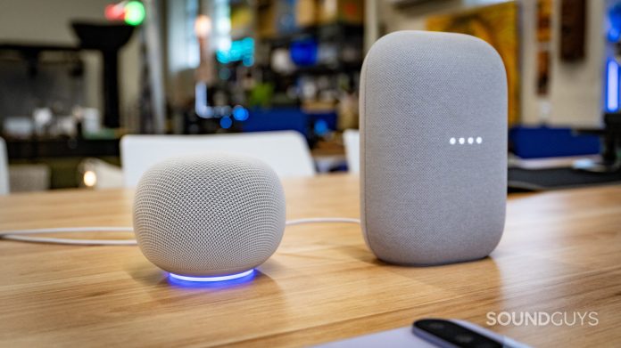 google home speaker beside google nest audio on a wooden table